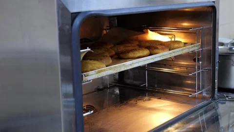 Close-up of the chef putting a tray of rolls in the oven for baking. Catering. Stock Footage 318659576