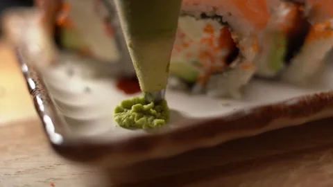 Close-up of a chef putting wasabi paste on a plate of sushi in a restaurant Stock Footage 250520147