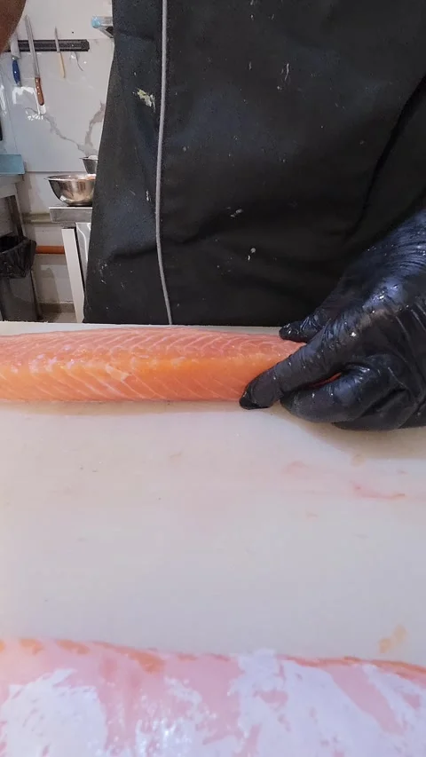 Close-up of chef removing pin bones from fresh salmon fillet with tweezers Stock Footage 314447857