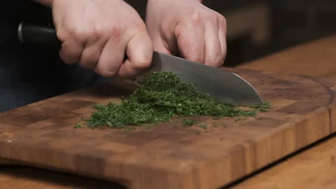 Close up chef in restaurant kitchen cut dill with sharp, shiny knife. man Stock Footage 151051373