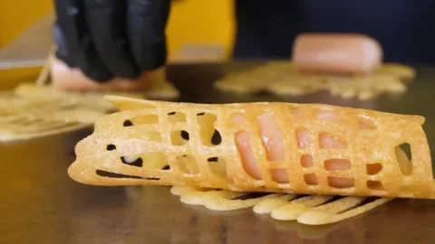 Close-up of Chef Rolling Crispy Net Crepe with Hot Dog on Griddle Stock Footage 345692609