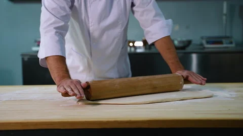 Close-Up of Chef Rolling Dough with Pin Stock Footage 299648480