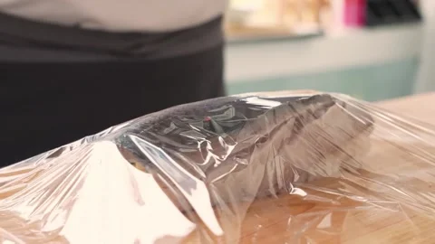 Close-up of Chef Rolling Sushi with Plastic Wrap Stock Footage 333501869