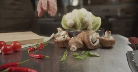 Close-up of chef rolls big beautiful mushroom on wooden board. 4K Slow Motion Stock Footage 123366671
