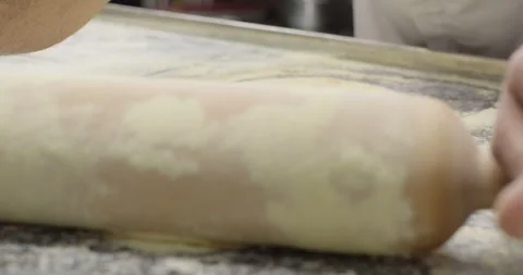 Close-up chef rolls out the dough. Male hands with rolling pin rolling out the Stock Footage 267900480