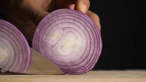 Close up on a chef s hands slicing a fresh shallot on a wooden chopping board Stock Footage 160551523
