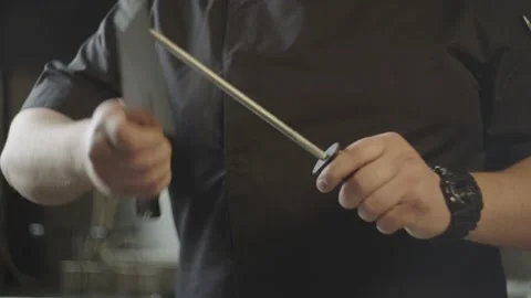Close-up of a chef sharpening a knife in the kitchen. Stock Footage 233615729