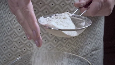 Close-up of a chef sifting flour through a metal sieve to make Cookie Dough. Video stock 309302528