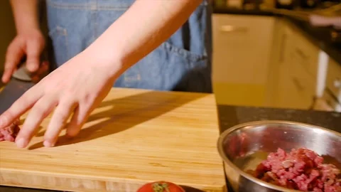 Close-up of a chef skillfully slicing raw meat on a cutting board. Stock Footage 194495418