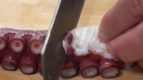 Close-up of Chef Slicing Boiled Octopus Tentacle for Sashimi on Wooden Board Stock Footage 333527092