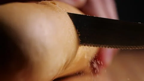 Close-up of chef slicing bread with bread crumb on wooden cutting board Stock Footage 130617343