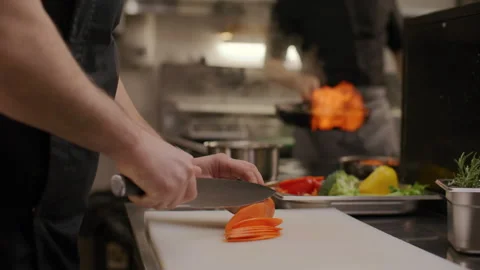 Close Up of Chef Slicing Carrot on Prep Board in Restaurant Kitchen Vidéo 330062276
