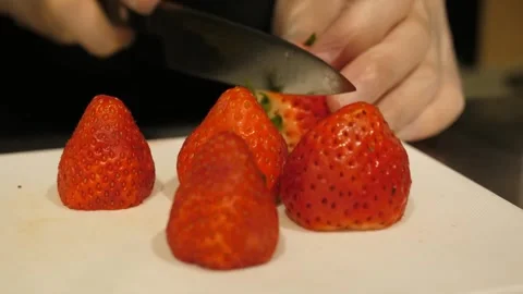 Close-Up of Chef Slicing Fresh Strawberries on a White Cutting Board Stock Footage 345292822