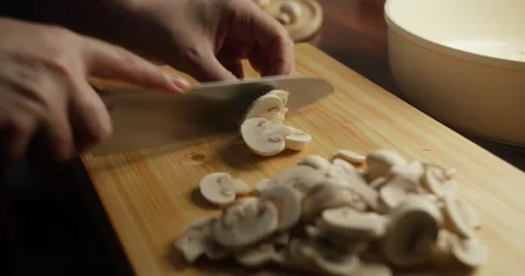 Close-up of a chef slicing fresh white mushrooms on a wooden cutting board Vídeos de archivo 327961474