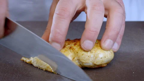 Close-up of a chef slicing fried chicken fillet on a dark kitchen board. Stock Footage 305386606
