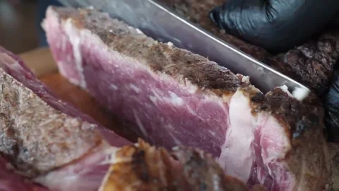 Close-up of Chef Slicing Juicy Medium-Rare Grilled Beef Steak on Wooden Board Stock Footage 338210868