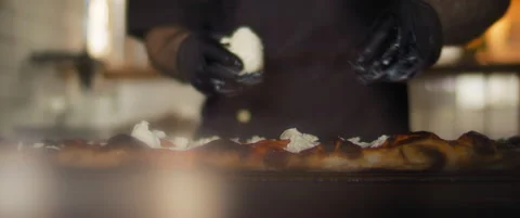 Close up of a chef spreading burrata cheese over a traditional al taglio pizz Stock Footage 146605879