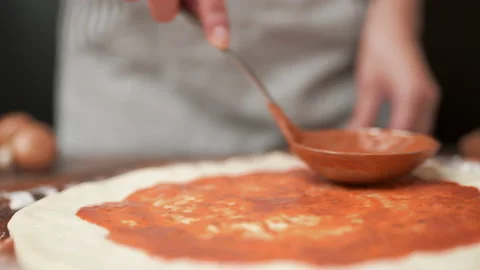 Close-up of chef spreading Tomato Sauce on pizza dough with a ladle in 4K. Stock Footage 137476724