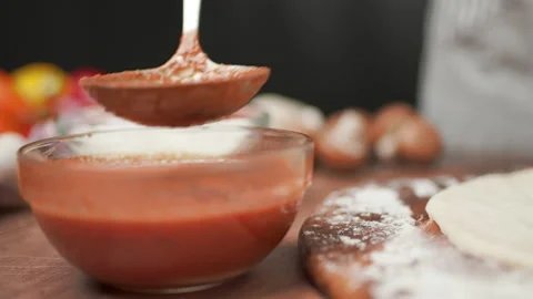 Close-up of chef spreading Tomato Sauce on pizza dough with a ladle in 4K. Stock Footage 137477141