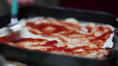 Close Up of Chef is spreading Tomato Sauce on Pizza Dough with a Metal Ladle   Stock Footage 142094093
