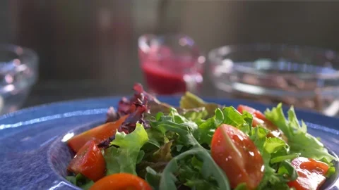 Close-up. The chef sprinkles cashew nuts on bright juicy greens with tomatoes. Stock Footage 154890165