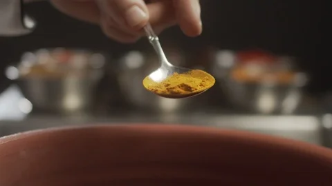 Close-up of chef sprinkles curry or curcuma on dish. Slow motion video Stock Footage