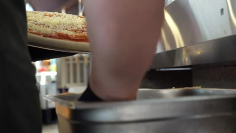 Close-up of a chef sprinkling grated cheese on a pizza in a restaurant kitchen. Stock Footage 341550825