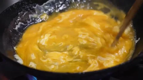 Close-Up of Chef Stirring Beaten Eggs in a Hot Pan Video stock 347688832