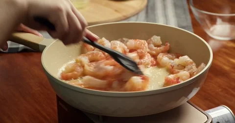Close up of chef stirring cooked orange shrimp with silicone spatula in a frying Stock-Footage 334758429