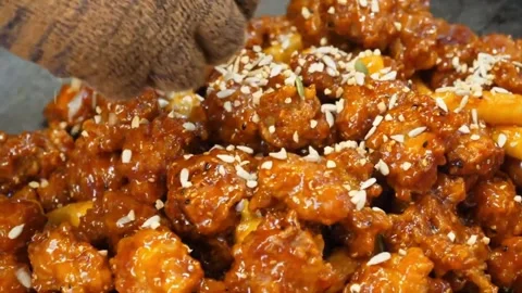 Close-Up of Chef Stirring Crispy Sesame Chicken with Wooden Spoon 스톡 동영상 343027281