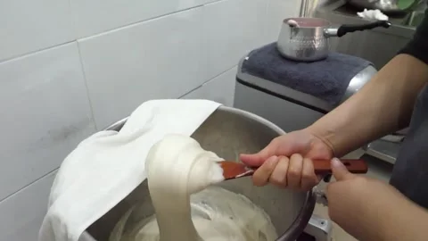 Close-Up of Chef Stretching and Kneading Sticky Rice Cake Dough in Kitchen Stock Footage 345291841