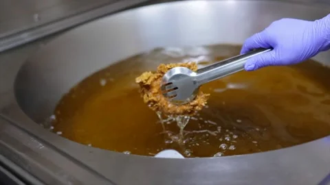 Close-Up of Chef Taking Deep Fried Chicken out of Oil with Tongs Stock Footage 288576446