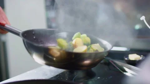 Close-up of Chef Tossing Broccoli in a Hot Pan Stock Footage 339565795