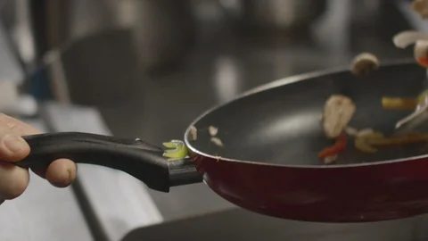 Close-up of chef tossing ingredients in frying pan. Slow motion video Stock Footage 114417022