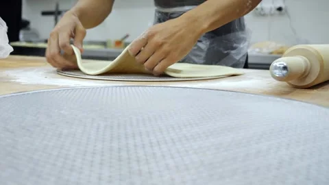Close-up of the chef tossing the pizza dough and placing it on a baking tray. 库存影片 340245675
