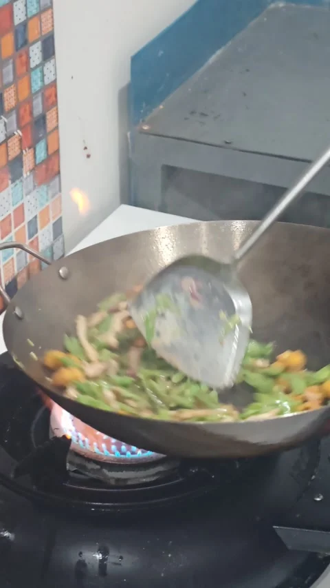 Close-up of a chef tossing vegetables and tofu in a wok over a high-flame ga Video stock 327065084