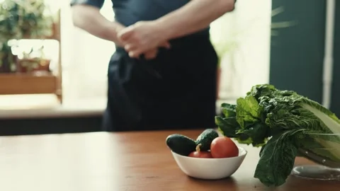 Close Up of Chef Tying Black Apron Strings Before Cooking in Kitchen Stockbeeldmateriaal 347134261