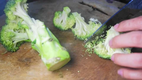 Close up chef using kitchen knife cutting fresh green broccoli  Stock Footage 142538626