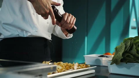Close up: the chef is using pepper mill to add some pepper to his food, salt  Stock Footage 201928858