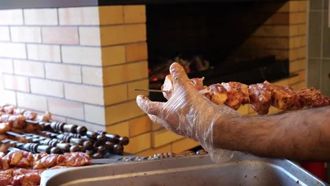 Close-up of a chef wearing gloves stringing marinated pork meat on a skewer. Stock Footage 320877703