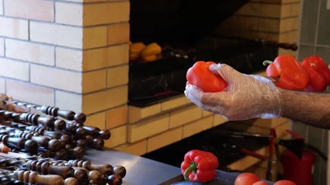 Close-up of a chef wearing gloves stringing peppers on a skewer before grilling Stock Footage 321814574