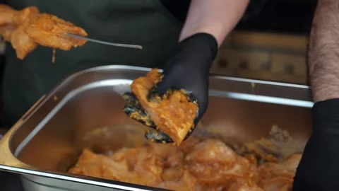 Close-up of a chef wearing gloves stringing marinated pork meat on a skewer. Stock Footage 341316872