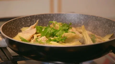 Close up of a chef while mixes olive oil, parsley and artichokes to prepare v Stock Footage 126316938