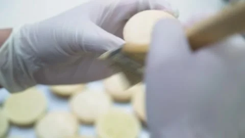 Close-up of Chef in White Gloves Brushing Glaze on Macaron Shells Stock Footage 343019494
