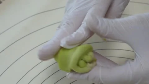 Close Up of Chef in White Gloves Kneading Green Dough on Silicone Baking Mat Stock Footage 345293414