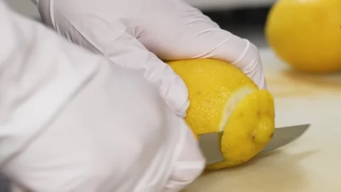 Close-up of Chef in White Gloves Slicing Fresh Juicy Lemon for Dessert Preparati Stock Footage 337751185