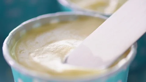 Close-up chefs are using a spatula spread cream cheese on a blue cupcake Stock Footage 104086088