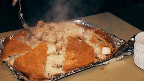 Close-up of a chef's chef cutting a knife firm dish - pilaf baked in bread Video stock 117377831