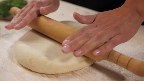 Close up of the chef's female hands roll the dough with a wooden rolling pin. Video stock 227343909
