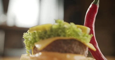Close-up of chef's hand covers half bun on hamburger. 4K Slow Motion Stock Footage 116173664
